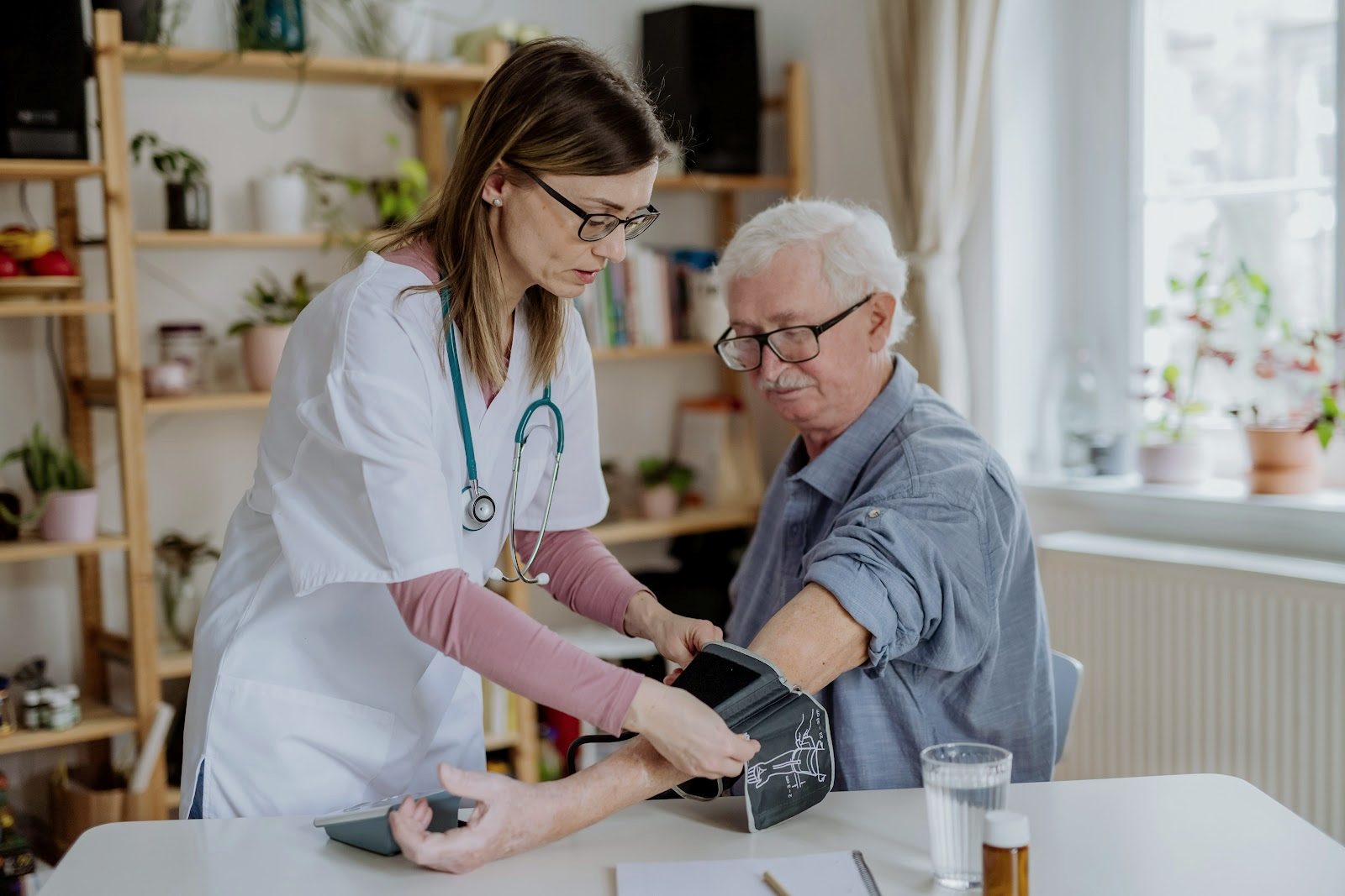 A Nexstep nurse checks an older man’s blood pressure during a home visit